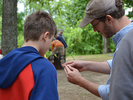 Archaeologist shows volunteer the notching in a projectile point at the Chapel Branch West Site.